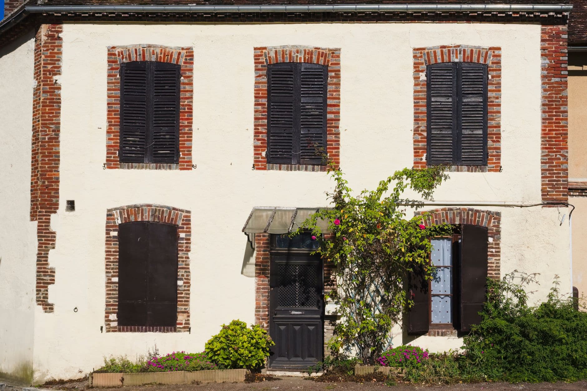 Façade d'une maison de famille française aux volets clos.
