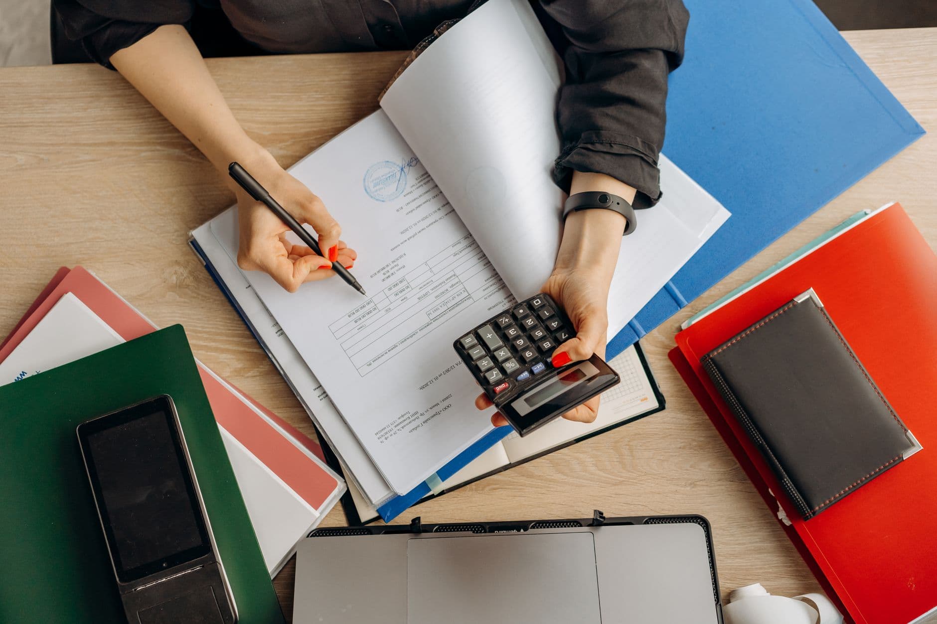 Vérification de comptabilité en milieu administratif avec documents et calculatrice.